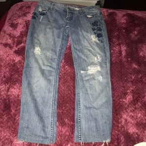 Blue ripped jeans with nice flower decorations.